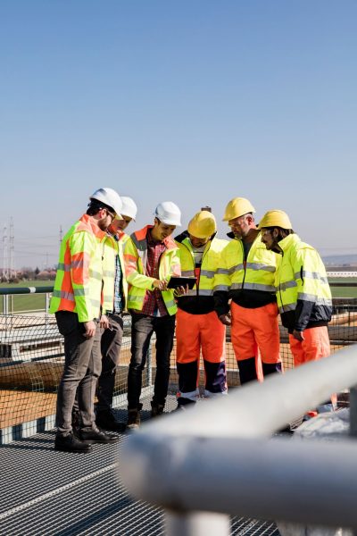 Engineers and workers assessing wastewater plant performance on tablet Engineers and workers assessing wastewater plant performance on tablet